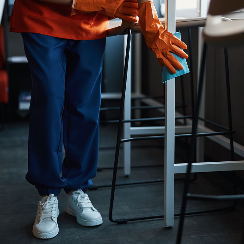 personne nettoyant une surface de bureau faisant parti de la société agent propreté